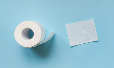 Top view of white roll and sheet of toilet paper on blue background