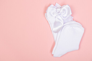 high white children's socks for girls with big bows for party wear on a pink background