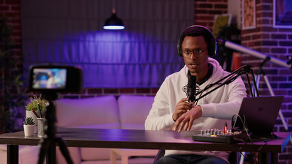 African american content creator recording vlog using digital video camera saying thank you for watching his show in home studio. Famous influencer streaming live internet entertainment podcast.