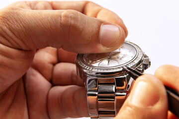 Watchmaker's job. Closeup male hands holding mechanical watches isolated over white background. Concept of vintage retro mechanisms, work, ad