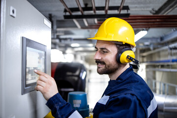 Worker operating modern industrial machine in production plant.