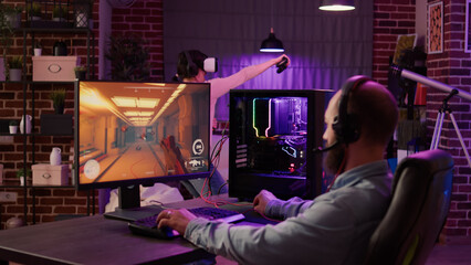 Gamer streaming first person shooter on pc while woman uses vr goggles for simulation in living room. Man playing multiplayer online action game while gaming girl is fighting in virtual reality game. © DC Studio