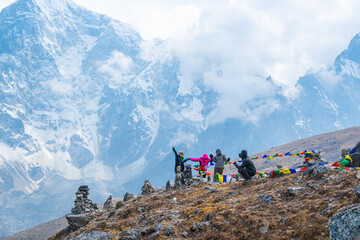 Trekkers and colorful prayer flags on the Everest Base Camp trek in Himalayas, Nepal. View of Mount Everest and Mountain Peak Nuptse