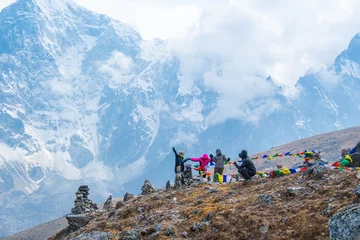 Papier Peint photo Ama Dablam Trekkers and colorful prayer flags on the Everest Base Camp trek in Himalayas, Nepal. View of Mount Everest and Mountain Peak Nuptse