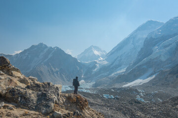 Naklejka na ściany i meble Male backpacker enjoying the view on mountain walk in Himalayas. Everest Base Camp trail route, Nepal trekking, Himalaya tourism.