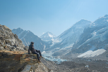 Fototapeta na wymiar Male backpacker enjoying the view on mountain walk in Himalayas. Everest Base Camp trail route, Nepal trekking, Himalaya tourism.