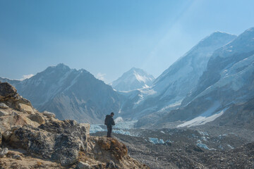 Male backpacker enjoying the view on mountain walk in Himalayas. Everest Base Camp trail route, Nepal trekking, Himalaya tourism.