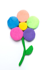 Fototapeta na wymiar multicolored plasticine flower on white background, children's creativity