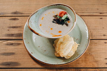 There are a small plate of soup with vegetables and two slices of bread