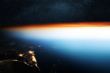 Amazing beautiful blue planet Earth with sunset and light of night cities. Night is falling on the planet. Space wallpaper