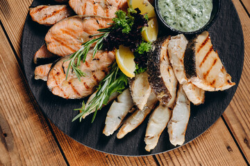 There is a interesting dish with lemon and sauce in front of the person in the restaurant.