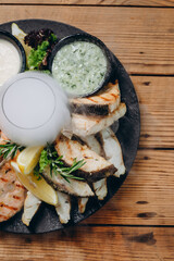 There is a wonderful steamy dish with leafs, cream and fish in front of the client in the cafe.