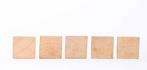 Fünf quadratische Holzsteinen in einer Reihe vor weißem Hintergrund als Vorlage oder Mockup. Leere Scrabblesteine.