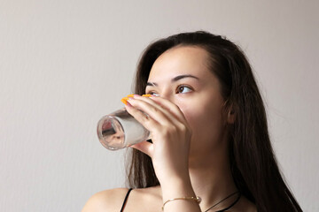 Pretty young girl drinking clean water, glass in female hand close up. Concept of thirst, diet, mineral drink, skin care