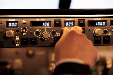Obraz premium Pilot aviator fixing altitude and longitude level on dashboard in plane cockpit. Pilot pushing buttons on control panel switch, using windscreen in aircraft cabin to fly airplane. Close up.