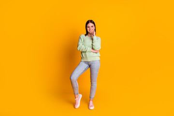 Fototapeta na wymiar Full body photo of young pretty woman standing hand touch chin isolated over yellow color background