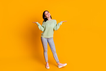 Full length photo of young cheerful woman hold hands promoter advertise isolated over yellow color background