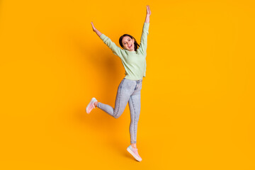 Fototapeta na wymiar Full length photo of young pretty woman rejoice hands up jumper isolated over yellow color background