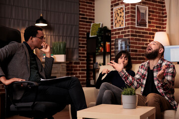 Male psychotherapist doing psychoanalysis of people at couple therapy, trying to solve relationship difficulties at counseling session. Angry man talking about fight and conflict, find solution.