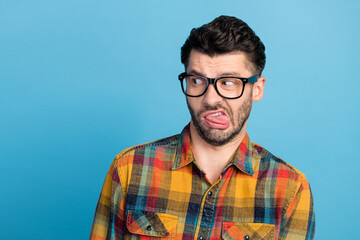 Photo of dislike brunet guy look empty space wear eyewear plaid shirt isolated on blue color...