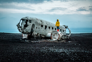 Woman in yellow jacket on Solheimasandur Plane Wreck in Iceland