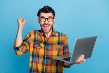 Photo of hooray brunet guy hold laptop yell wear eyewear plaid shirt isolated on blue color background