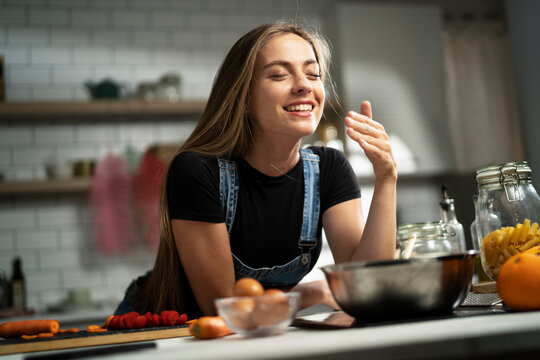 Young woman in kitchen. Beautiful woman making delicious food..