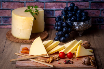 Kashar cheese or kashkaval cheese on wood floor. Cheese slices on the serving board