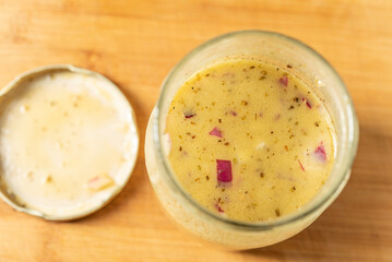 Drips of Oil and Dressing into a glass container in preparation for a salad dressing.
