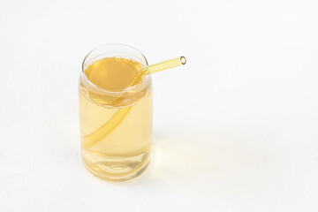 Homemade kombucha fermented drink in glass and colored reusable eco-friendly straw on white background. Heathy probiotic beverage with bubbles. Summer non alcoholic drinks. Copy space