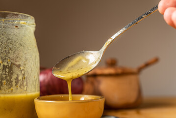 Drips of Oil and Dressing into a glass container in preparation for a salad dressing.
