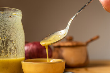 Drips of Oil and Dressing into a glass container in preparation for a salad dressing.