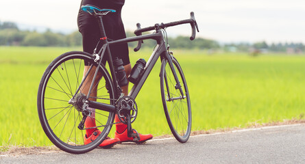 Fototapeta premium Rear view of a cyclist on the road in the evening. Fitness concept.