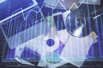 Financial market graph and top view computer on the desktop background. Multi exposure. Investment concept.