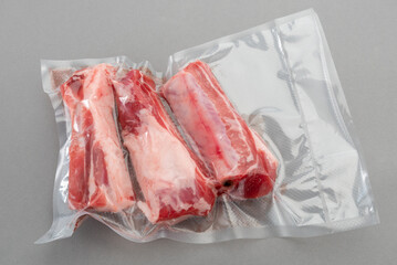 Pork ribs in vacuum packed sealed for sous vide cooking on gray background in top view.