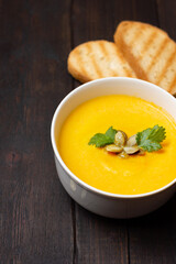 Vegetarian autumn pumpkin soup with seeds and parsley.