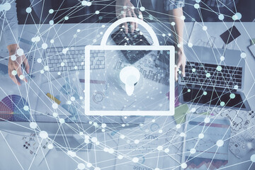 Double exposure of man and woman working together and technology theme lock drawing hologram. Security concept. Computer background.