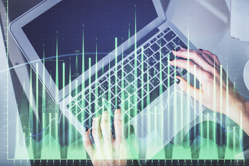 Double exposure of woman hands working on computer and forex chart hologram drawing. Top View. Financial analysis concept.