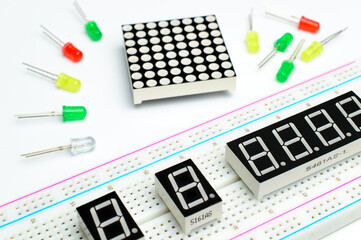 Breadboard close-up, seven segment indicators and color led lamp. LED matrix and colorful diodes. Concept of a DIY arduino project. Background picture.
