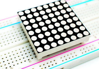8x8 LED arduino matrix attached to a breadboard on white background. Concept of a technical project. Selective focus. Background picture. Top view.  