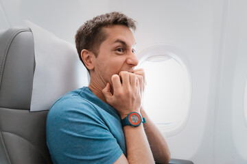 Young man is afraid to fly on an airplane and emotionally screams in fear. Panic attack and...