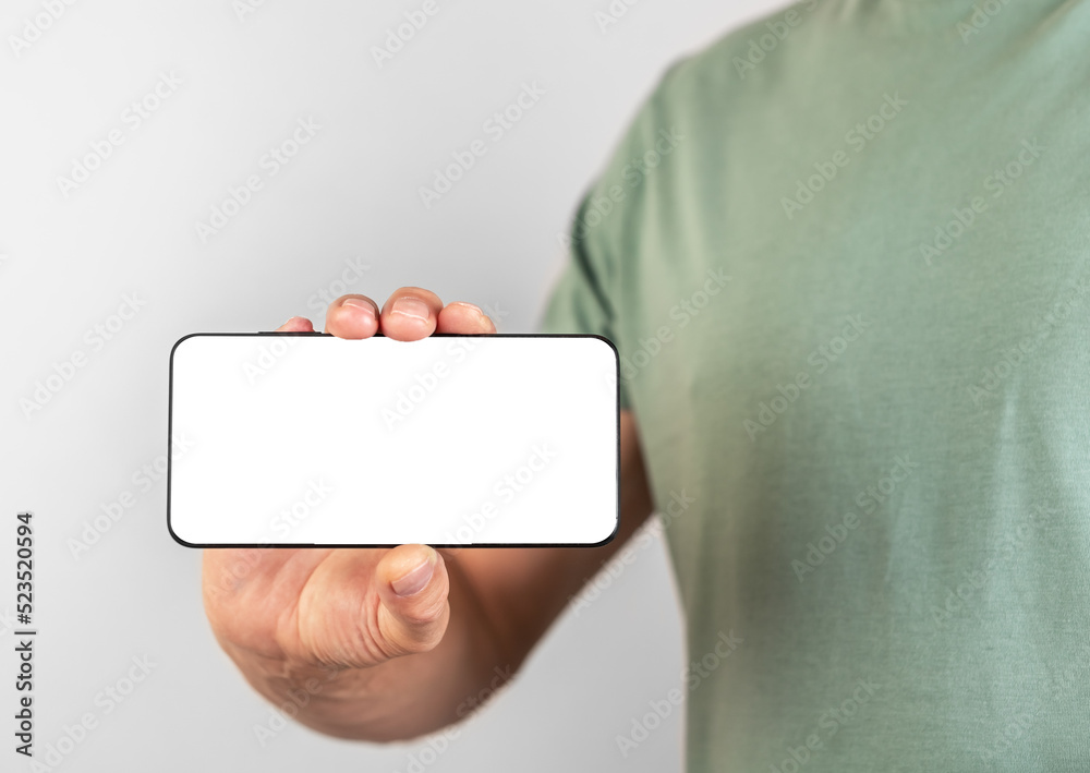 Poster Man holding phone mockup in horizontal position. Person using smartphone for showing video or photo. Android with white display