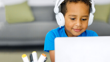 Black student child doing homework using computer literature while looking at the screen