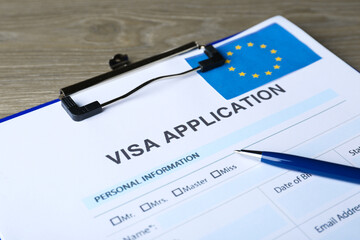 Visa application form for immigration to European Union and pen on table, closeup