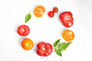 Frame of different ripe tomatoes and leaves on white background, flat lay. Space for text