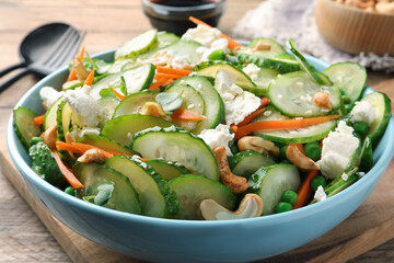 Delicious cucumber salad on wooden table, closeup