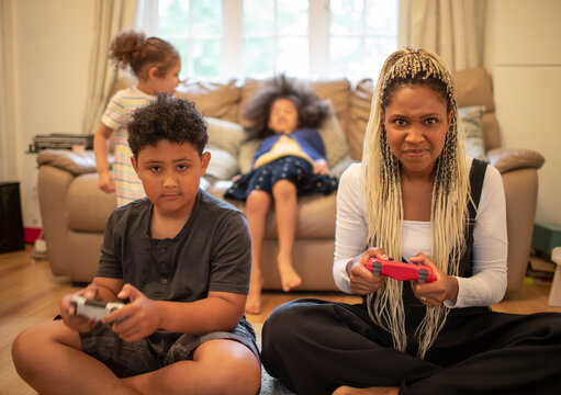 Portrait serious mother and son playing video game