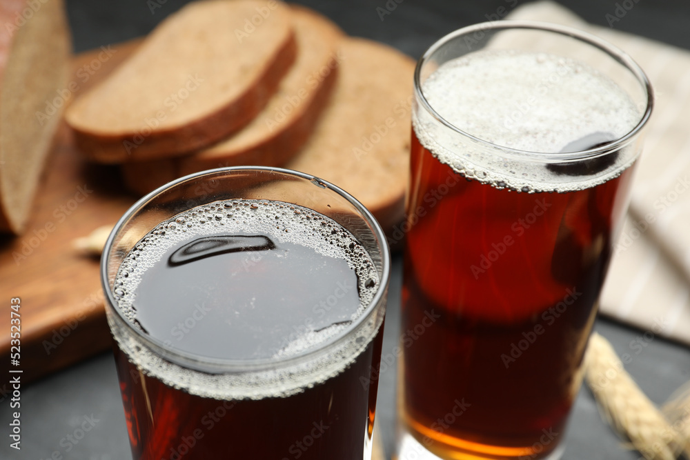 Wall mural glasses of delicious kvass on black table, closeup