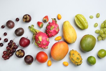 Many different delicious exotic fruits on light background, flat lay
