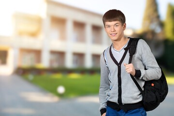 Happy school, college or university student with backpack. Cheerful handsome young man smiling
